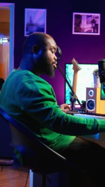 Vertical Video Songwriter kendi stüdyosunda yeni şarkılar yaratmak için notlar alıyor, şarkı sözleri ve harmonik unsurlar yazıyor yazılımını kaydetmeden önce, akustik, akustik