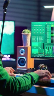 Vertical Video Creative söz yazarı mikrofon ve Midi kontrolörüyle yeni şarkılar kaydediyor, ev stüdyosunda piyano çalıyor. Elektronik klavye ve stereo ile müzik besteleyen yetenekli bir müzisyen
