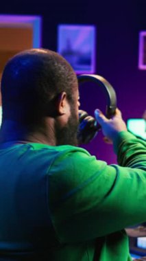Dikey Video Müzik bestecisi yeni bir şarkı için ses efekti, elektronik piyano sentezleyicisinden ses kaydı ekliyor. Şarkı sözü yazarı ses teknisyeni yazılımda melodileri düzenleyip karıştırıyor. Kamera.