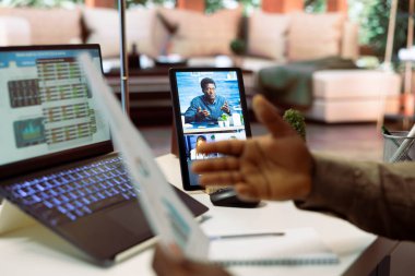 İşadamı, hissedarlarla birlikte evindeki bir video görüşmesinde mali raporları inceliyor. Uzmanlar, yeni işletme fonları sağlamak için genişleme planlarını inceliyorlar. Başlangıç büyümesi.