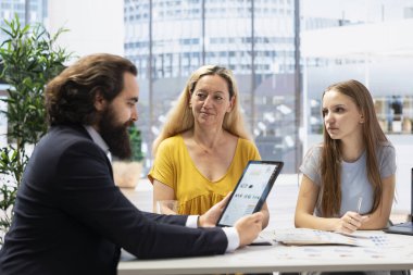 Finansal danışman tabletteki yatırım performansı hakkında raporlar ve istatistik tabloları hazırlıyor ve bunları müşterilere gösteriyor. Müşteri portföy grafikleri geliştirmek için aygıt kullanan aracı