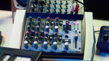 Müzik üretmek için konsol ve dengeleyiciyle karıştırıcı olarak kullanılan motorlu faders ve ön amfi düğmeleri olan boş stüdyo masası. Karışık ve usta için yükseltici ve aygıtlara sahip modern uzay.
