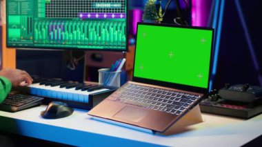 Müzik yapımcısı dijital post prodüksiyon pc arayüzü, yeşil ekran ekranında şarkıları karıştırıp ustalaştırıyor. Sanatçı ses efektleri ekliyor ve ses seviyelerini yeni müzik üretmek için ayarlıyor. Kamera A.