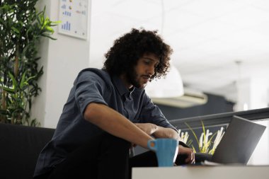 İşletme ofisinde dizüstü bilgisayarda sunum yapan bir şirket yöneticisi başlat. Genç yakışıklı Arap girişimci bilgisayar üzerinden satış verilerini ve mali raporlarını kontrol ediyor