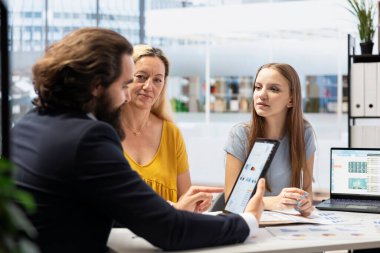 Finansal danışman müşterilerle uzun vadeli yatırım stratejileri oluşturmak ve istatistik şemalarını göstermek için çalışıyor. Profesyonel, ailelerin verileri kullanarak gerçekçi finansal hedefler ve yol haritaları belirlemelerine yardımcı olur