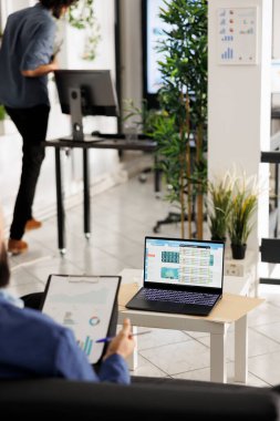 Finansal analist, şirketlerin ortak çalışma alanındaki dizüstü bilgisayar ekranında hisse senedi açılımını ve yatırım gelirini analiz ediyor. İşletme ofisindeki bilgisayarda bilgi ve diyagramları kontrol eden yönetici yönetici.