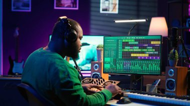 Afrika kökenli Amerikalı müzik yapımcısı düğmeleri karıştırma konsolunda çeviriyor, ses efektleriyle şarkılar üretiyor. Prodüksiyon sonrası şarkılar besteleyen sanatçı, ev stüdyosunda dijital yazılımla çalışıyor. Kamera A.