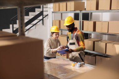 Çeşitli stok odası ekibi, panoda müşteri siparişlerini kontrol ediyor, depoda paketler hazırlıyor. Depo çalışanları karton kutuları nakliye için kullanıyorlar. Depo kavramı