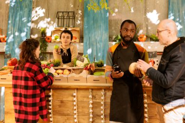 Çeşitli çiftçiler, hasat festivalinde organik ev yapımı ürünler sergiliyor. Kafkasyalı kadın satıcı olarak çalışıyor, elmayı kavrıyor, taze toplanmış meyve ve sebze satıyor..