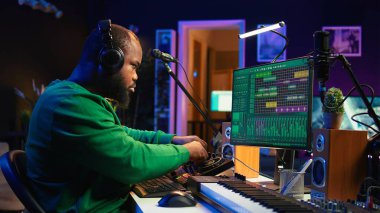 Yetenekli müzik yapımcısı konsol ve daw yazılımları üzerine yeni soundtrack besteler, ev stüdyosunda stereo teçhizatla çalışır. Genç mühendis amfi düğmeleri ve sinyal işleme kullanıyor. Kamera B.