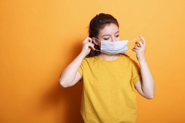 Beyaz kadın portresi koruyucu bir yüz maskesi takıyor. Koronavirüse karşı korunan bir kadın. Bir salgın sırasında yetişkinler kendilerini korumak zorundadırlar..