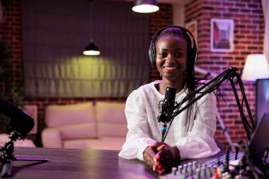 Stüdyodaki profesyonel ekipman kullanılarak yapılan internet ünlüleri kayıt bölümünün portresi. Neşeli içerik oluşturucu izleyicilerle konuşuyor ve sosyal medya kanalı vlog 'unu çekiyor