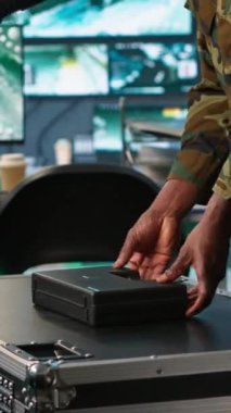 Komuta merkezindeki askerlerden oluşan dikey video ekibi uzun menzilli hedeflere saldırabilecek silahları topluyor. Askeri birlikler silah fişeklerini dolduruyor. Düşman saldırı görevi için hazırlanıyorlar. Kamera A.