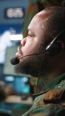 Telsiz ve uydu donanımı kullanarak savaş desteği sağlayan dikey video ordu telekomünikasyon sistemi operatörü. Askeri sevk memuru iletişim ağlarını yönetiyor, ekranlara bakıyor, kamera A