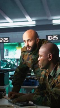 Telsiz ve uydu donanımı kullanan dikey video ordu telekomünikasyon operatörleri sistemlere veri girişi yapıyor. İletişim ağlarını yöneten askeri sevkiyatçılar, klavyede daktilo, kamera B