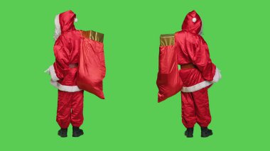 Noel Baba karakteri, stüdyo ortamında Noel tatilinin reklamını yapmak için kırmızı hediye torbalarıyla poz veriyor. Pazarlama için Saint Nick somutlaştırması.