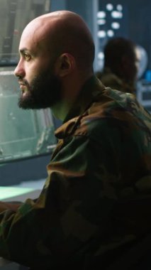 Komuta merkezindeki krom anahtar ekranlara bakan dikey ordu askeri balistik roketleri durdurmak için tasarlanmış operasyonel füze savunma sistemine bakıyor. Model izleme donanımı kullanan bir uzman