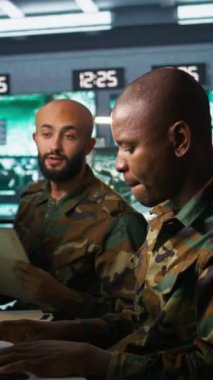 Dikey video ekibi askeri ajanları düşman savaş düzeni hakkındaki istihbarat dosyalarına bakıyor. İstihbarat teşkilatı iş arkadaşları, rakip strateji ve kamera hakkında bilgi toplamak için görev belgelerini okuyor.