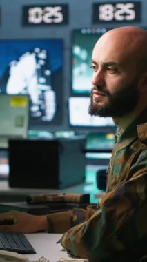 Dikey videocu, askeri karargahtaki füze savunma sistemindeki balistik roketleri durdurmak için tasarlanmış ekranlara bakıyor. Özel kuvvetler uzmanı izleme cihazı ve radar kullanıyor.