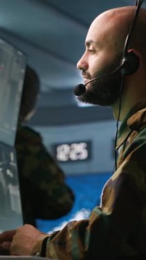 Dikey video askeri hareket memuru kulaklık mikrofonuyla ön saflarda savaşan piyade birliklerine bilgi veriyor. Askerler için istihbarat sağlayan ordu uzmanı, görev faaliyetlerini koordine eden, kamera