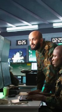 Askeri telekomünikasyon operatörlerinden oluşan dikey video ekibi telsiz ve uydu donanımı kullanarak savaş desteği sağlamak için işbirliği yapıyor. Haberleşmeyi yöneten ekip çalışması yapan askeri görevliler.