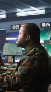 Komuta merkezindeki dikey video subayı, meslektaşı tarafından düşman birlikleri hakkında bilgi toplamak, analiz etmek ve planlamak için kullanıldı. Operasyon üssündeki ajanlardan oluşan bir ekip düşmanları değerlendiriyor.