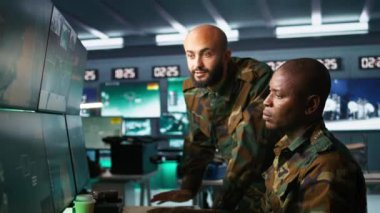 Hava kuvvetleri subayları komuta merkezinde taktik seviye keşif yapıyor ve monitörlere bakıyor. Askeri askerler saldırı bölgelerine bakmak için radar cihazları kullanıyor, kamera B