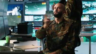Askeri ajan kontrol odasında arttırılmış gerçeklik teknolojisi kullanıyor, hava keşif verilerini analiz ediyor. İstihbarat birliği uzmanı AR hologramı ve kamera A ile stratejik hedeflere saldıran İHA 'ları kontrol ediyor.