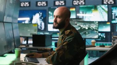 Askeri karargah üssündeki füze savunma sistemindeki balistik roketleri durdurmak için tasarlanmış ekranlara bakan adam. Takip cihazları ve radar sistemleri kullanan özel kuvvetler uzmanı, kamera A