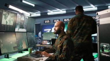 Askeri ajan kontrol odasında çalışıyor, hava keşif verilerini analiz ediyor. İstihbarat Teşkilatı ajanı İHA 'ları kontrol ediyor stratejik hedeflere saldırıyor, Kamera B
