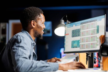 Finans uzmanı harcamalar ve kârlar üzerine strateji oluşturmadan önce kayıtlardan kaynak dağıtım detaylarını okuyor. Yasal profesyonel ve mali planlama tarafından yürütülen denetim operasyonları.