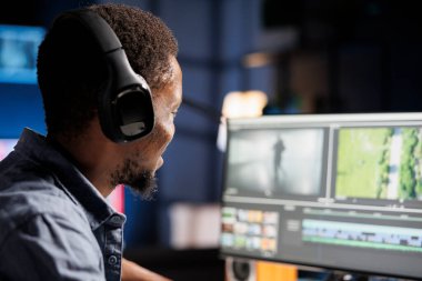 Videograf uzmanı bilgisayardaki film kliplerini ayarlıyor, renk tekeriyle çalışıyor ve görsel efektler ekliyor. Afro-Amerikan video editörü post prodüksiyon için fx montaj yapıyor.