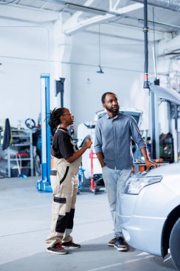 İnsan arabasının bakım parametrelerini göstermek için AR teknolojisi kullanan bir tamirci. Garaj çalışanı, araçtaki hatalar hakkında müşteriyi bilgilendirmek için fütüristik vr kulaklık kullanıyor.