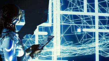 Sönük aydınlatılmış sunucu odasını denetleyen, tablet üzerinde kod çalıştıran, sorun çıkaran ve sunuculardan, ağ sistemlerinden ve depolama dizilerinden oluşan teknolojik olarak gelişmiş donanım kümelerini güncelleyen yönetici