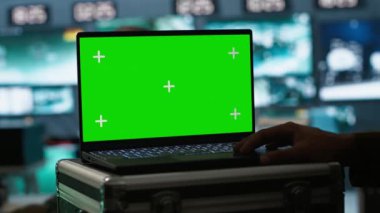 Ordu telekomünikasyon sistemi operatörü yeşil ekran teçhizatı kullanıyor, savaş desteği sağlıyor. Askeri sevkiyat memuru iletişim ağlarını kontrol ediyor. Model laptop, kamera A ile.