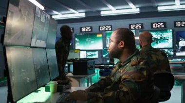 Hava kuvvetleri subayı ve meslektaşı komuta merkezinde taktik seviyesinde gözlem yapıyorlar. Askeri uzmanlardan oluşan bir ekip beyin fırtınası yapıyor, saldırı bölgelerine bakmak için radar donanımı kullanıyorlar, kamera B