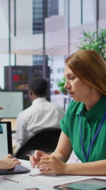 İş başvurusunu değerlendiren ve seçim sürecinde özgeçmişlerini inceleyen dikey video insan kaynakları personeli, kurumsal iş teklifi. İş tecrübesine dayanarak adayları seçen alıcılar