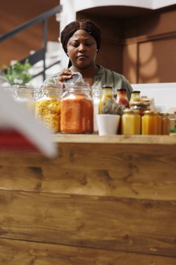 Siyahi bir kadın şef, çevre dostu bir süpermarkette organik ve yerel olarak yetişmiş ürünler arıyor. Çevre dostu tencere ve konteynırları kullanarak sağlıklı yaşama ve sıfır israfa değer veriyor..
