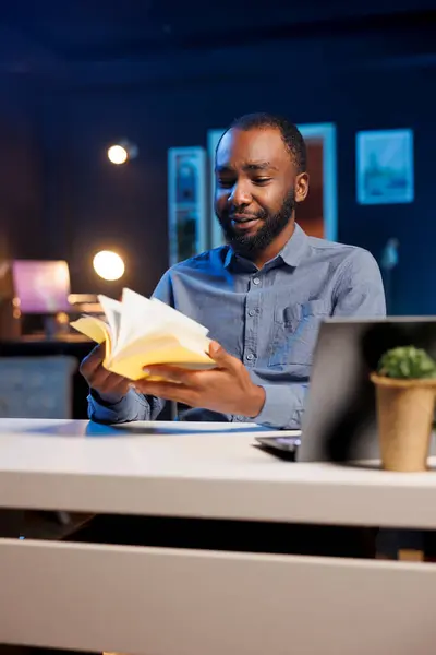 stock image BIPOC content creator doing literature critique for his online streaming channel audience. Reviewing commenting on new book release significance, doing video essay for viewers