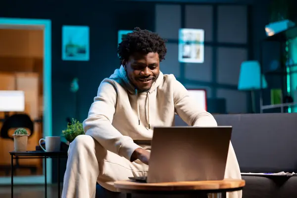 stock image Cheerful freelancer working from home using laptop to send emails. Smiling remote employee typing on notebook keyboard, delivering finalized project paperwork to management