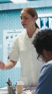 Dikey Video Uzmanı, tedavi hizmetlerini tartışmak için bir bölüm toplantısına başkanlık ediyor, kollektif çalışmaları geliştirmek için personelle test sonuçlarını analiz ediyor. Yardım için sağlık kayıtlarını kullanmak.