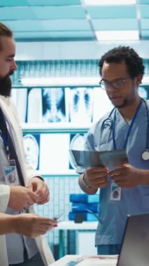 Dikey Video Hastanesi uzmanları röntgenleri gözden geçirir ve araştırma toplantısında tedavi stratejisini tartışırlar. Radyoloji ve hastalık önleme alanında uzman doktorlar sigorta hizmetleri için işbirliği yapmaktadırlar.