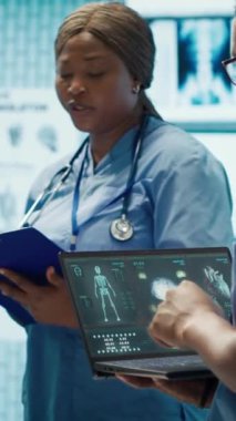 Dikey video uzmanları röntgen sonuçlarını gözden geçirir ve bir toplantıda hasta bakımı stratejilerini tartışırlar. Lisanslı sağlık uzmanlarından oluşan bir ekip bir klinikte doğru teşhis koymaya çalışıyor.