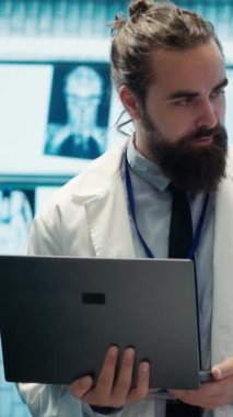 Dikey video nörobilim uzmanı MRI beyin taraması sonuçlarını doktorlarla birlikte inceleyerek hastalıkların önlenmesi için doğru tedavi planını tartışıyor. Lisanslı nörolog ve ekibi tomografiyi inceliyor.