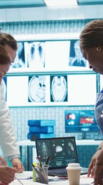 Uzmanlardan oluşan dikey video ekibi, özel bir klinikte yapılan bir toplantıda, hastalıkların önlenmesi için kardiyovasküler sistem analizi ile sonuçlanır. Taramalar ve kayıtlar için danışmanlık. Kamera.