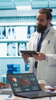 Dikey Video Nöroloji uzmanı, bir toplantı sırasında beyin taraması yapan bir manyetik rezonans uzmanını inceleyerek, doğru nörobilim teşhisi için tomografiye bakar. Çeşitli doktor takımları.