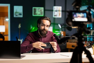 Entertainer sponsorluk videosundan cep telefonunu sunar, izleyicileri satın almaya çağırır, profesyonel kamerayla çekim yapar. Seyircilere akıllı telefon reklamı yapan adam, özel ekipmanla kayıt yapıyor.