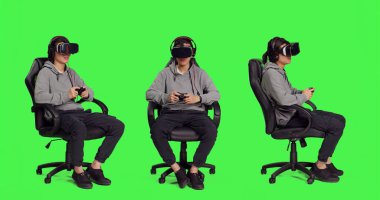 Video kulaklığı takmış Asyalı bir adam kamerada yeşil ekran arka planına karşı oynuyor, joystick ile video oyunları oynuyor. Rpg meydan okuma ve sanal gerçeklik aktivitesiyle eğlenen genç kişi.