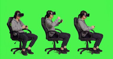 Asyalı adam yeşil ekran setinde sanal gerçeklik kulaklığı takıyor ve oyun kontrolörüyle video oyunlarından zevk alıyor. Genç yetişkin roket yarışması ve modern kulaklıkla eğleniyor..
