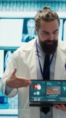 Dikey Görüntü Uzmanı Sıhhiyeci, MR beyin taramasını tıbbi ofisindeki ekibiyle birlikte analiz ediyor. Nörobilimci çeşitli doktorlarla tomografiyi inceliyor. Tedavi merkezinde nörobilim uzmanları